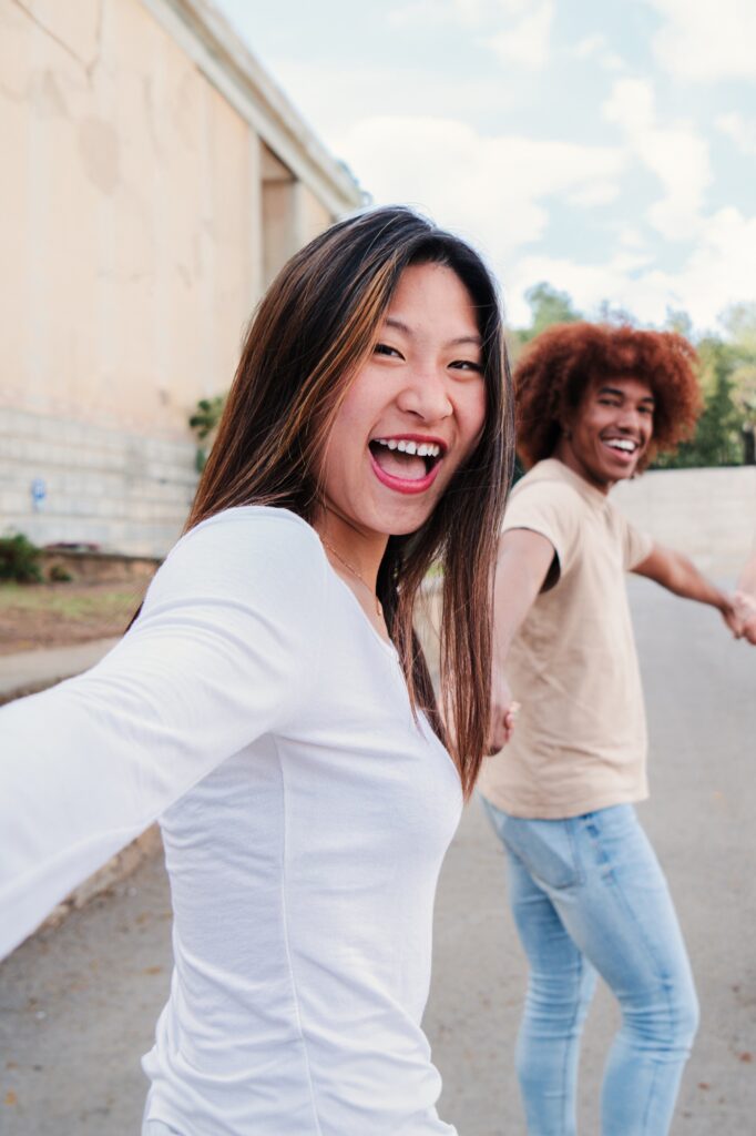 Vertical point view portrait of a multiracial group of friends walking holding hands. pov of young