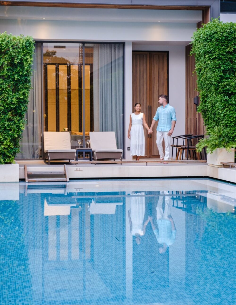 Luxury 5 star hotel pool in Asia A couple of men and women on vacation at a luxury hotel resort,