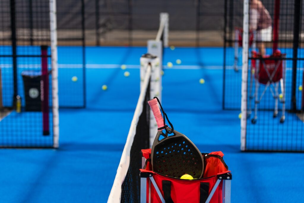 balls near the net of a blue padel tennis court