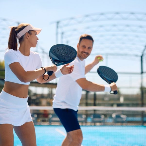 Athletic woman having paddle tennis exercise class with her coach.